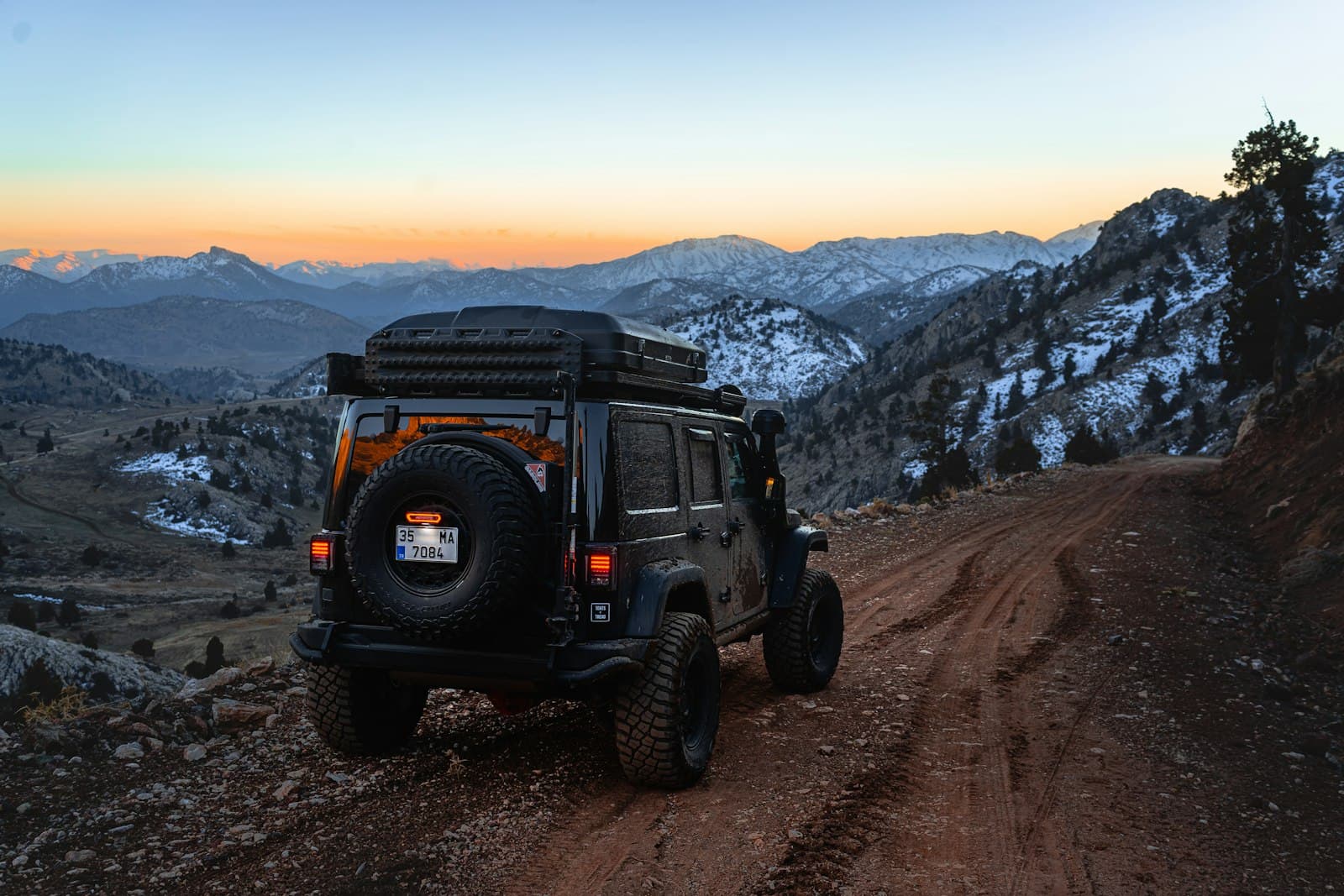 Véhicule 4x4 aménagé équipé sur une piste de montagne au crépuscule
